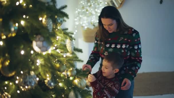 Оформление Веселый Малыш Наряжает Рождественскую Елку Готовит Комнату Санта Клауса — стоковое видео
