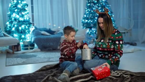 迷人的礼物 快乐的小男孩打开圣诞树旁的圣诞礼物 圣诞老人魔法 情感和孩子惊喜的喜悦 高质量的4K镜头 — 图库视频影像