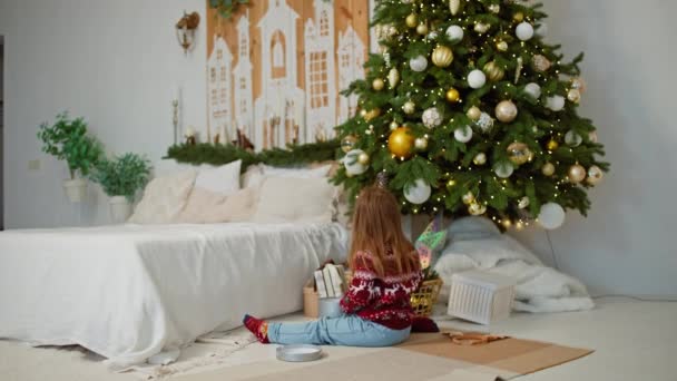 Χαρούμενη Αποπυγμαχία Δώρο Κοριτσάκι Παίζοντας Βασίληδες Παρουσιάζει Κοντά Στο Χριστουγεννιάτικο — Αρχείο Βίντεο