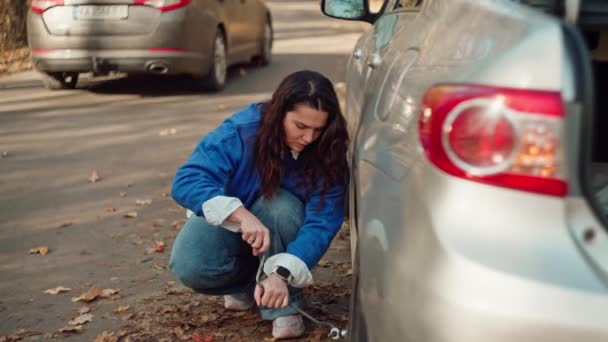 Navigating Natures Hurdles Gritty Girl Confronts Automotive Breakdown Skillfully Changing — Vídeo de stock