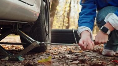 Traversing Forest Roads: Şahit The Determination as a Courageous Girl Difront Auto Trouble, Master Changing a Tire during her Adventurous Journey. Yüksek kalite 4k görüntü
