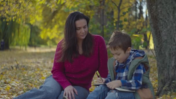 Tranquil Autumn Scene Mother Son Engage Serene Study Session Amidst — Stock Video