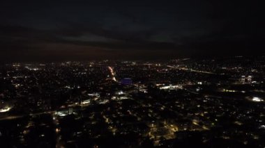 Gece Şehir Darbesi: Sokak Işıkları ve Araba Farları ile aydınlatılan Kentsel Manzaraların Hava Keşfi. Yüksek kalite 4k görüntü