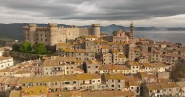 Bracciano İtalya 'daki kalenin havadan görünüşü. Avrupa 'da bir göl manzarasında bir dağın tepesinde çok güzel bir antik savunma sporu. Yüksek kalite 4k görüntü