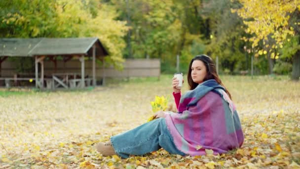 秋天的交响曲 在秋天的心 一个美丽的女人喝着温暖的茶 裹着阳光般的黄色围巾 高质量的4K镜头 — 图库视频影像