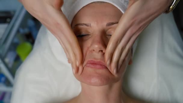 Närbild Ansiktet Äldre Kvinna Som Masseras Kosmetolog Förberedelser För Skönhetsingrepp — Stockvideo