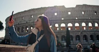 Güzel bir kadın turist Kolezyum yakınlarında selfie çekiyor. Roma 'daki antik Roma mimarisinin yakınlarındaki anılar için seyahat fotoğraflarının mutlu anları. Yüksek kalite 4k görüntü
