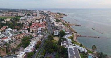 Kıbrıs Rum Kesimi 'nin Paphos kentinin havadan görünüşü. Akdeniz kıyısında tatil beldeleri ve otelleri olan bir adada, turistik bir kentin setindeki şehir yolu. Yüksek kalite 4k görüntü
