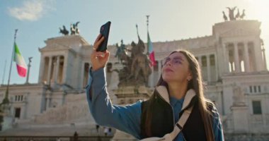 Roma sokaklarında yürüyen bir kız turist hatıra olarak fotoğraf çekiyor. Unutulmaz yaşam tarzı seyahatleri. Yüksek kalite 4k görüntü