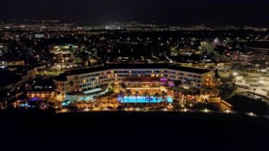 Paphos Kıbrıs 'ın gece şehir manzarası. Akdeniz adasında bir sürü evi ve oteli olan turistik bir yerin şehir ışıkları. Yüksek kalite 4k görüntü
