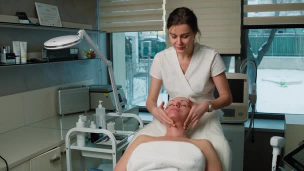 Cosmetologo Massaggio Viso Paziente Clinica Pelle Che Stringe Procedure Bellezza — Video Stock