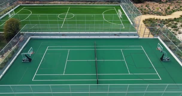 山の風景の中のテニスコートの空中ビュー 路上で活発なスポーツライフスタイルである緑の草の上にテニスをするための2つの裁判所 高品質の4K映像 — ストック動画
