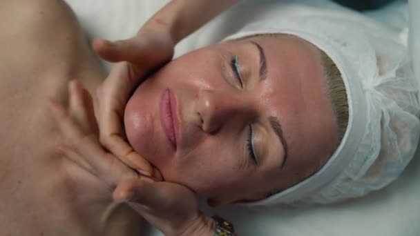 フェイシャルマッサージを受ける女性の顔のクローズアップ 化粧品の美容プロシージャのための皮膚の準備 高品質の4K映像 — ストック動画