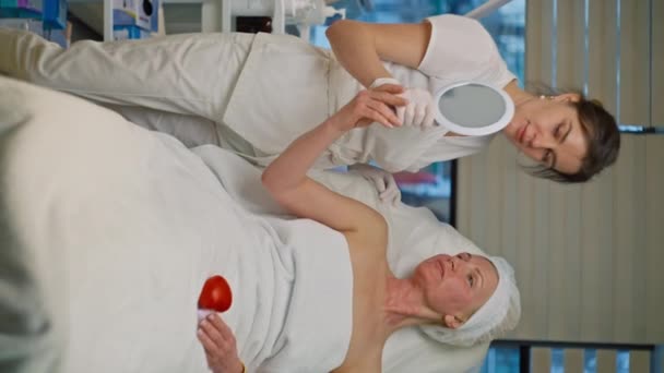 Kosmetolog Pokazuje Wynik Kobiecie Lustrze Starsza Kobieta Spotkaniu Kosmetycznym Zabiegach — Wideo stockowe