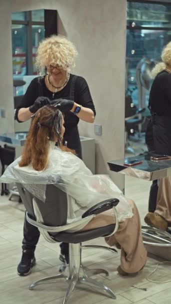 美容師が美容室で女性の髪を染めている ヘアケア プロの染料毛 高品質の4K映像 — ストック動画