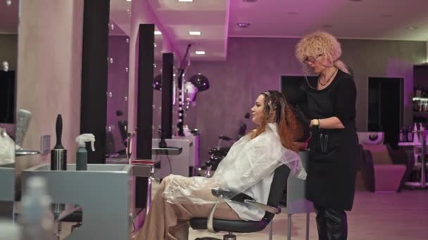 在美容院染女人的头发理发师用一根骨头改变了女孩头发的颜色 高质量的4K镜头 — 图库视频影像