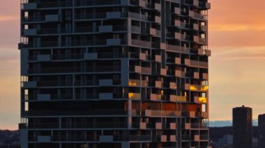 Viyana Avusturya 'da hava manzaralı şehir günbatımı. Gökdelendeki bir binanın camlarında güneş ışınlarının yansıması üzerine panoramik bir kentsel manzara. Yüksek kalite 4k görüntü