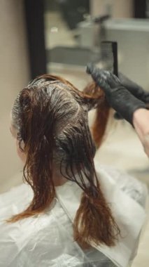Kadın saçı boyayan bir kuaförün yakın çekimi. Kuaförde yaşam tarzı güzellik prosedürleri. Yüksek kalite 4k görüntü