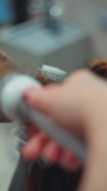 Bir kuaförün elleri, bir kadının saçını şekillendiriyor. Yüksek kalite 4k görüntü