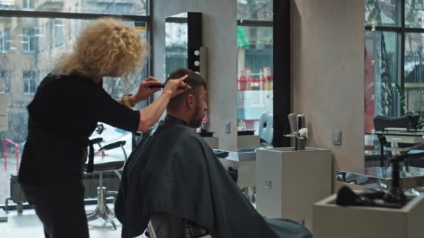一个女理发师给一个白人男人理发 美容院照顾男孩的头发和美丽 高质量的4K镜头 — 图库视频影像