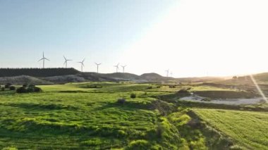 Gün batımında hava manzaralı rüzgar santrali. Doğanın güzel bir manzarasında yel değirmenleri, rüzgardan ekolojik elektrik üretimi. Yüksek kalite 4k görüntü