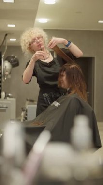 Şık saç kesimi ve saç stili: Profesyonel Kuaför, Güzellik Salonunda Güzel Avrupalı Bir Kadın İçin Makas Kullanıyor, Yaşam Tarzı Moda Görünümü Bir Profesyonel Tarafından Yaratıldı.