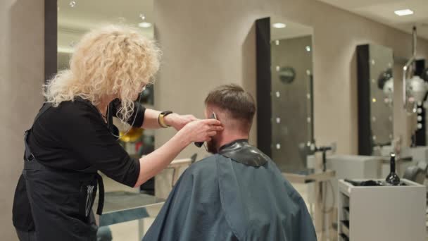 Fryzjer Kroi Białego Mężczyznę Salonie Piękności Fryzjer Robi Męskie Włosy — Wideo stockowe