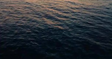 Deniz manzaralı günbatımı manzarası. Kızıl güneşin ışınlarında okyanusun güzel dalgaları. Yüksek kalite 4k görüntü