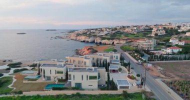 Kıbrıs, Paphos 'un havadan çekilmiş şehir manzarası. Akdeniz kıyılarında yüzme havuzları olan güzel modern villa mimarisi. Yüksek kalite 4k görüntü