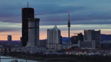 Viyana Avusturya 'da hava manzaralı şehir günbatımı. Gökdelenler, gece gündüz yükselen TV kuleleri, başkentin modern mimarisi.. 