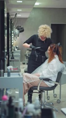 Uzman Saç Rengi Dönüşümü: Profesyonel Stilist Salon 'da Kadın Görünümü İçin Dikkatli Değişiklik Sağlıyor. Yüksek kalite 4k görüntü