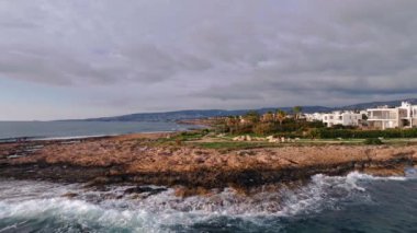 Sahil Serenity: Paphos 'un Hava Bakış Açısı, Kıbrıs Rum Kesimi Güzel Kıyı Mimarisi ve Karanlık' taki Doğal Manzara. Yüksek kalite 4k görüntü