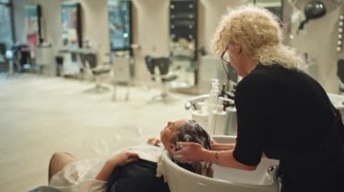 Şımarık Salon Deneyimi: Saç Yıkama ve Hazırlama İşkadını Şık Saçlı Ayarlar İçin Saç Tıraşı. Yüksek kalite 4k görüntü