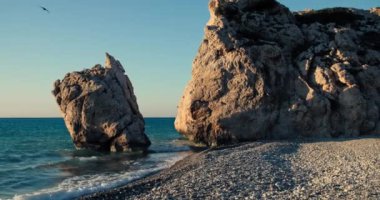 Kıbrıs adasındaki güzel bir sahil manzarası. Gün batımında kayalık bir kıyıya vuran deniz dalgalarının yavaş çekim videosu. Yüksek kalite 4k görüntü