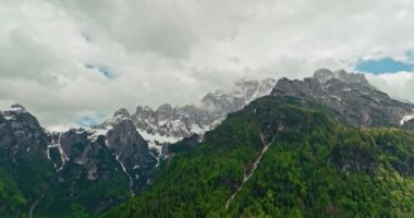 İtalya 'daki Dolomite Alpleri' nin güzel doğa manzarasının havadan görünüşü. Dağ yamaçlarında büyüyen ormanlar, karlı kayalık tepeler ve tepeler. Yüksek kalite 4k görüntü