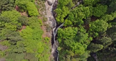 İtalya 'daki Dolomite Alpleri' nde bir şelalenin havadan görünüşü. Bir dağ nehri kayalar ve kayalar arasında akar ve dibe düşer, doğanın inanılmaz bir güzelliği. Yüksek kalite 4k görüntü