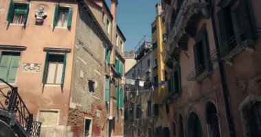 İtalya, Venedik sokaklarının mimarisi. Güzel bir şehir manzarası. Kanallardaki bir turist kasabasındaki binaların balkonundan sarkan çarşaflar. Yüksek kalite 4k görüntü