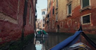 Venedik, İtalya 'nın kanallarında yüzen bir gondol görüntüsü. Romantik ve turistik bir şehrin güzel şehir manzarası ve mimarisi. Yüksek kalite 4k görüntü