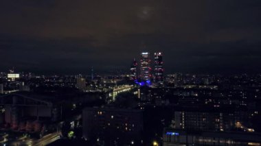 Milan Şehir Işıkları: İtalyan Şehri 'nin Gece Havadan Görünümü, Şehir Işıklarının Göz kamaştıran Parıltısı, Uzun Gökdelenler ve Aşağıdaki Bustling Caddeleri. Yüksek kalite 4k görüntü