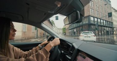 Beyaz kadın Milano, İtalya sokaklarında araba kullanıyor. Kız yağmurlu havada şehir trafiğinde çalışmak için acele eder. Yüksek kalite 4k görüntü