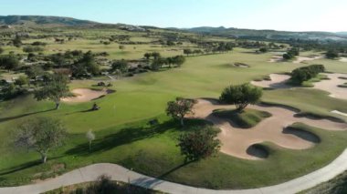 Kıbrıs 'taki Golf Sahalarının Havadan Görünümü - Sahildeki Ağaçlar ve Palmiye Ağaçları Manzarasında Golf Oynamak, Serene Coastal Setting' de Rahatlatıcı Bir Oyun Keyfi Vermek.