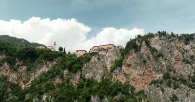 İtalya Garda Pieve Gölü 'nün havadan görünüşü. Güzel doğa. Dolomite Alpleri 'nin doğa manzarasında bir kayanın tepesindeki bir köyün binaları. Yüksek kalite 4k görüntü