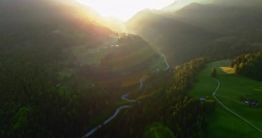 İtalya 'nın Dolomite Alpleri' nde güzel bir günbatımı manzarası. Güneş ışınları dağ sıralarının zirvelerinden yeşil tarlalara ve ormanlara doğru kırılıyor. Yüksek kalite 4k görüntü