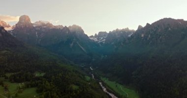 Alp Günbatımı: İtalya 'nın Dolomite Alplerinde Güneşli Günbatımının Hava Görüntüsü, Dağ Dağları, Yeşil Tarlalar ve Ormanlar' da Güneş ışınları parlıyor. Yüksek kalite 4k görüntü