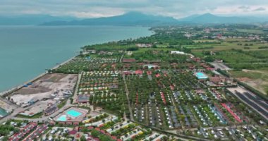 Hava manzaralı Garda Gölü Peschiera del Garda İtalya. Alp Dağları 'ndaki bir gölün kıyısındaki evlerin Sisky kentsel manzarası. Yüksek kalite 4k görüntü