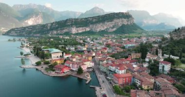 İtalya 'nın Riva del Garda kentinin havadan görünüşü. Dağların tepesinde güzel evler ve caddeleri olan bir dağ köyünde gün batımı. Yüksek kalite 4k görüntü