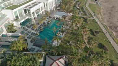 Kıbrıs Rum Kesimi 'nin Paphos kentinde tatil beldeleri bulunan havacılık manzaralı bir sahil şeridi. Deniz kenarında güneşli havuzlar, güzel bir manzarada havuzlar. Yüksek kalite 4k görüntü