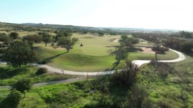 Kıbrıs 'taki golf sahalarının havadan görünüşü. Deniz kıyısında ağaçlar, tarlalar ve göllerle çevrili spor için güzel bir doğa. Yüksek kalite 4k görüntü