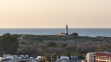 Kıbrıs 'ın Paphos kentindeki deniz fenerinin havadan görünüşü. Harabelerin yakınındaki adada turistik bir yer. Şehrin şehir manzarası. Yüksek kalite 4k görüntü