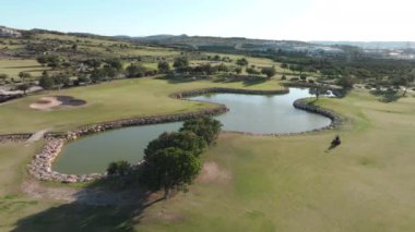 Kıbrıs 'taki golf sahalarının havadan görünüşü. Dağlar, göller ve ağaçlarla çevrili doğanın güzel manzarasında spor. Yüksek kalite 4k görüntü